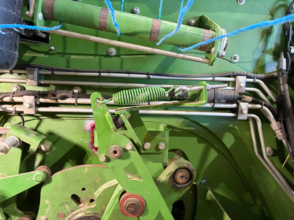 Red dye penetrant on the cracked area of a hay baler near Prairie, beside a bracket on the side of the baler
