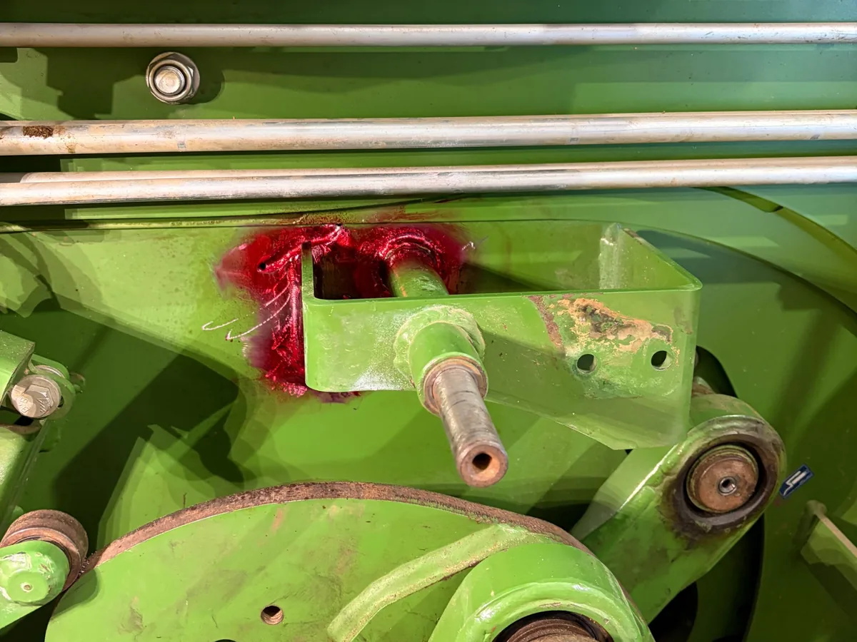 Red dye re-applied while grinding out the cracks on a hay baler near Prairie